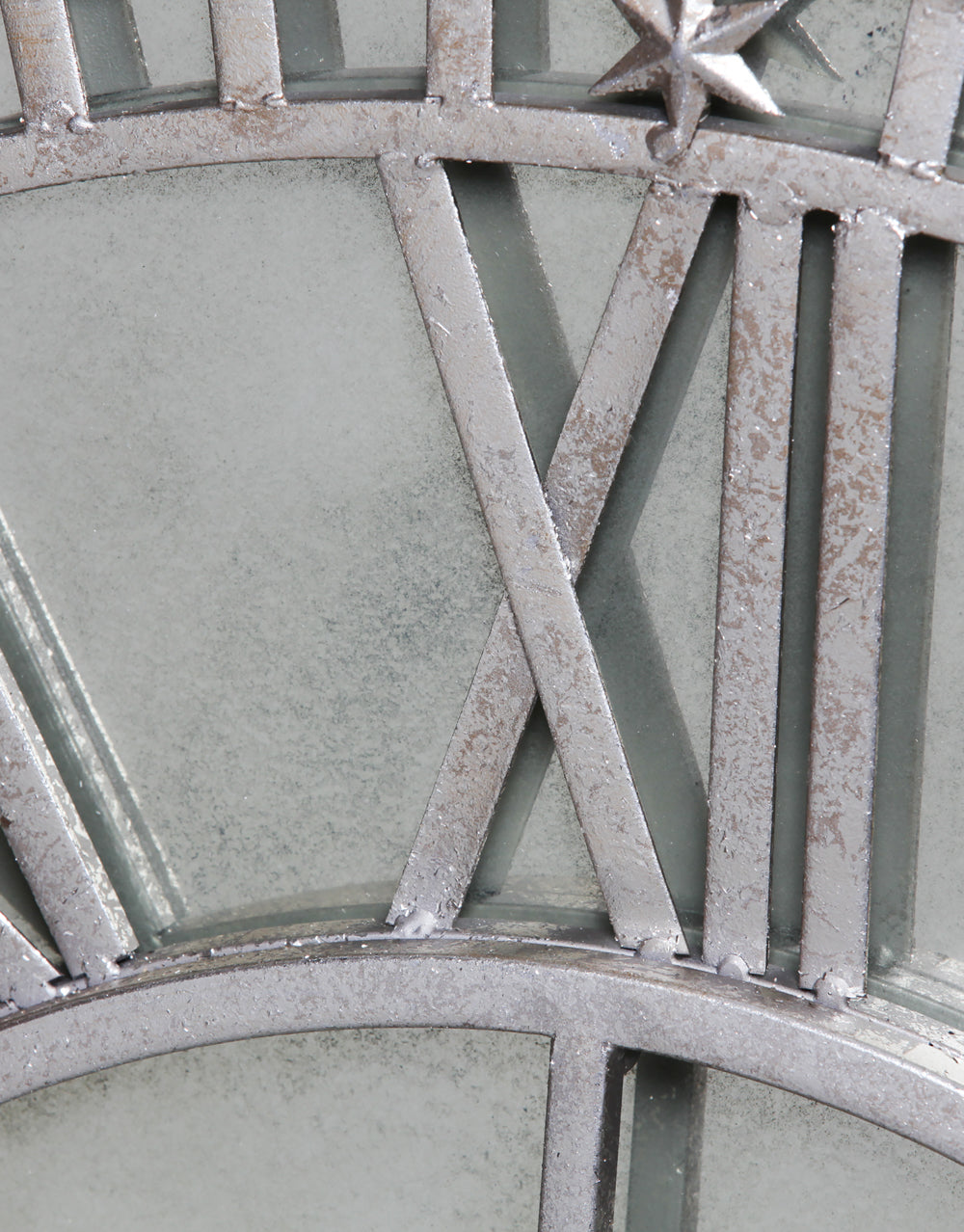 Large silver clock with antique mirror face.